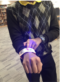 A student shows off their wearable tech creation - a bracelet that lights up.