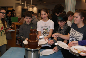 Students are gathered around a chocolate fountain.