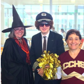 Three people are dressed up in Halloween costumes. The woman on the left side is dressed as a witch, the man in the middle is dressed as a ship captain, and the woman on the right is dressed as a cheerleader.
